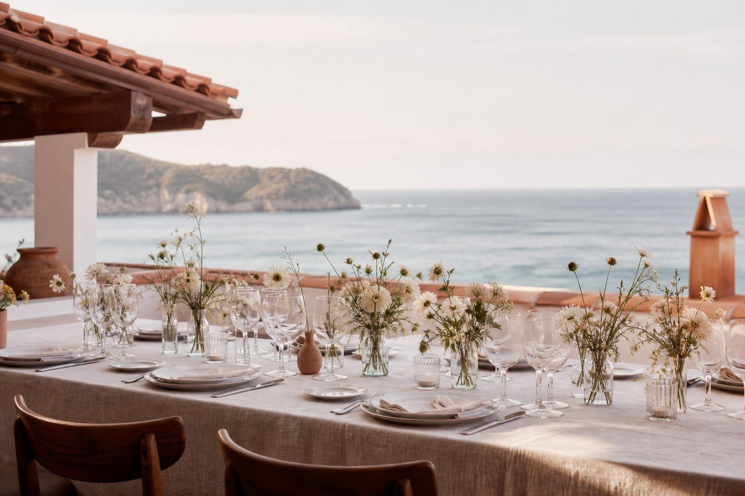 Long wedding table set for dinner on a Basque coast terrace at dusk