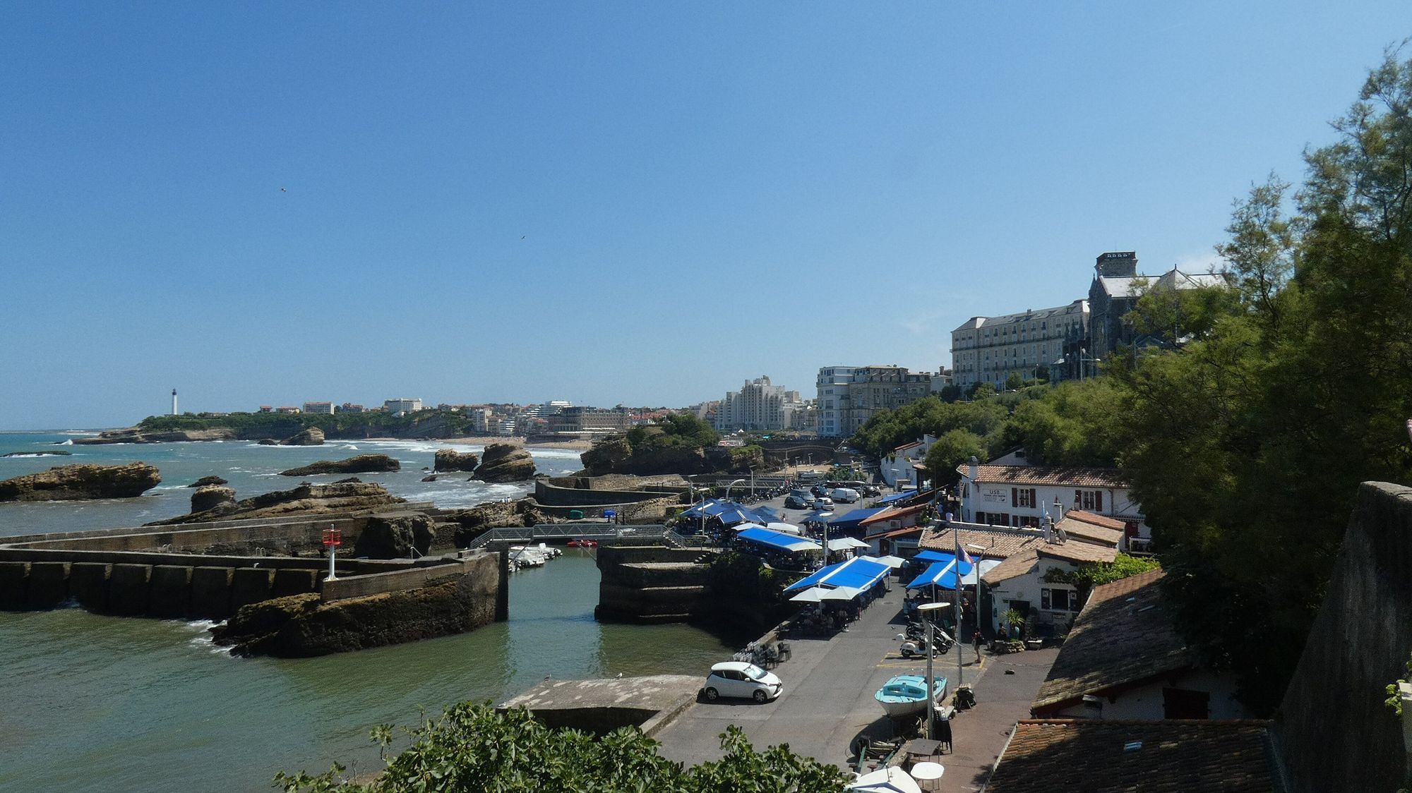 The Port des Pêcheurs in Biarritz, with boats and blue cafe awnings